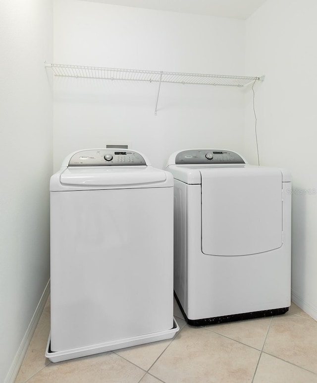 563 Copperdale Ave, Winter Garden, FL 34787 - washroom with light tile patterned flooring, baseboards, laundry area, and washer and dryer