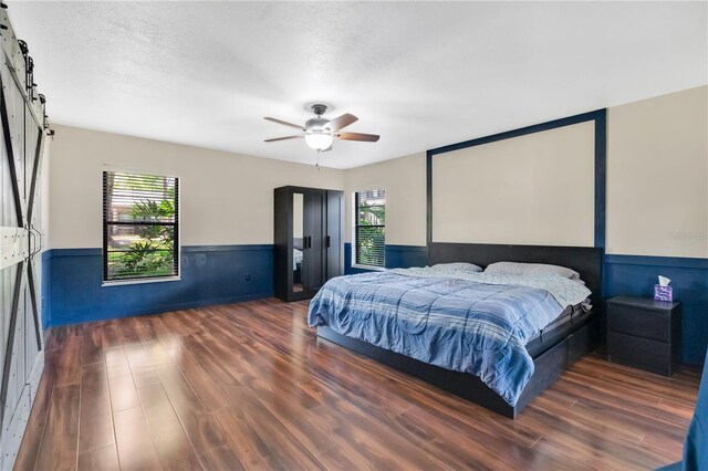 218 Nettlewood Ln, Fern Park, FL 32730 - bedroom with a wainscoted wall, wood finished floors, multiple windows, and a barn door
