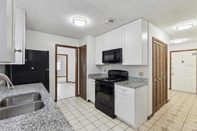 7602 Glenmoor Ln, Winter Park, FL 32792 - kitchen featuring light stone counters, a sink, white cabinets, visible vents, and black appliances