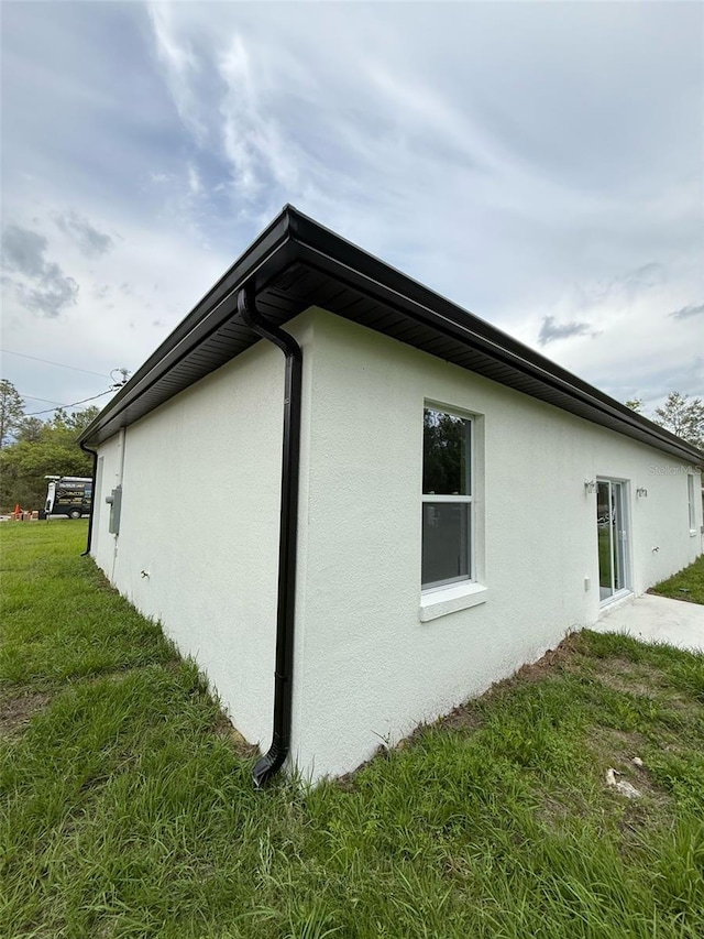54 Malauka Trak, Ocklawaha, FL 32179 - view of property exterior featuring stucco siding and a yard