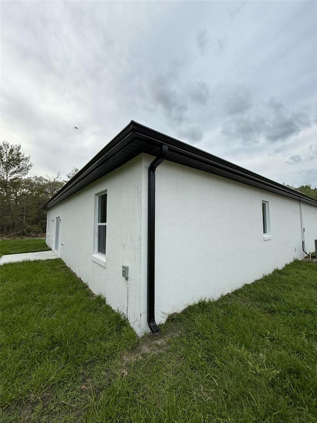 54 Malauka Trak, Ocklawaha, FL 32179 - view of home's exterior featuring a lawn and stucco siding