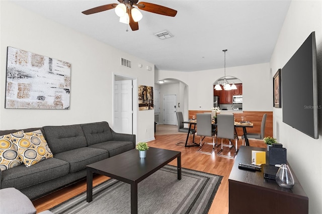 4114 Breakview Dr Unit 11002, Orlando, FL 32819 - living area featuring arched walkways, ceiling fan with notable chandelier, light wood-style floors, and visible vents