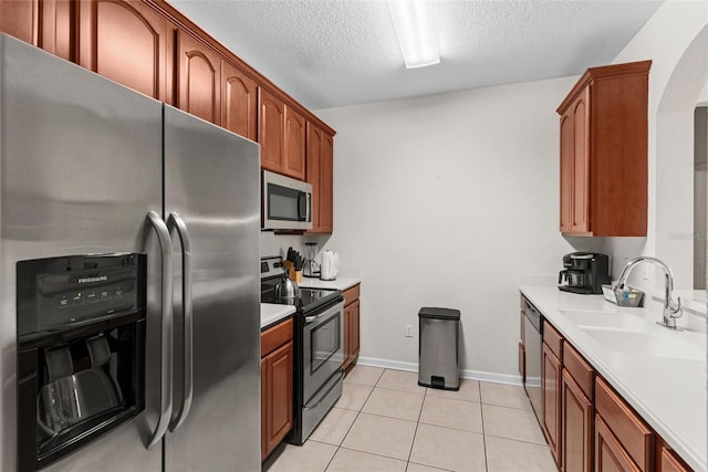 4114 Breakview Dr Unit 11002, Orlando, FL 32819 - kitchen featuring light countertops, a sink, light tile patterned floors, stainless steel appliances, and arched walkways