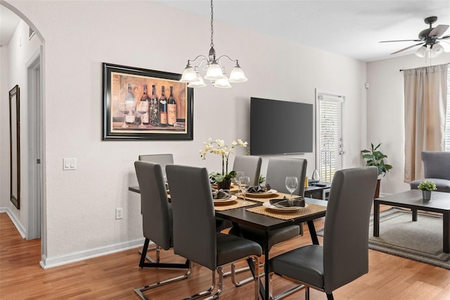 4114 Breakview Dr Unit 11002, Orlando, FL 32819 - dining room with arched walkways, baseboards, ceiling fan with notable chandelier, and light wood finished floors