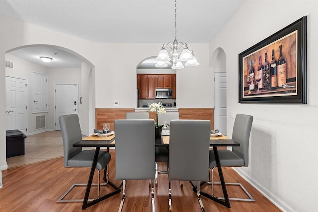 4114 Breakview Dr Unit 11002, Orlando, FL 32819 - dining room featuring light wood-style flooring, a notable chandelier, arched walkways, and visible vents