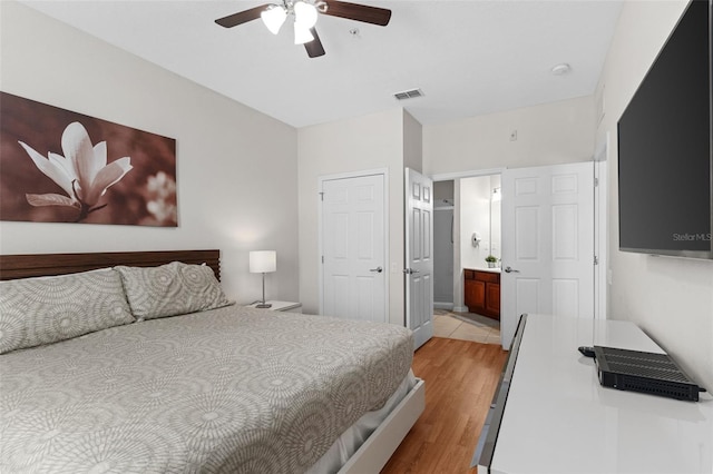 4114 Breakview Dr Unit 11002, Orlando, FL 32819 - bedroom with ensuite bath, ceiling fan, visible vents, and light wood finished floors