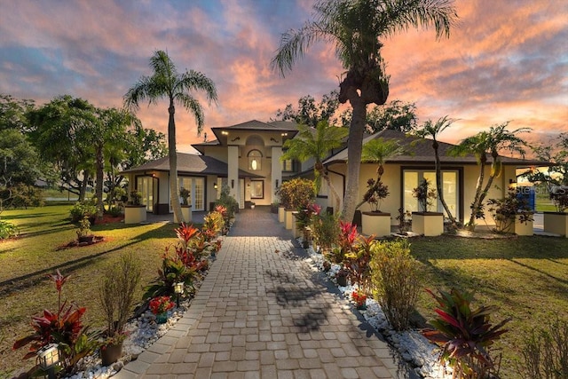 2910 Frontier Dr, Kissimmee, FL 34744 - mediterranean / spanish home with french doors, a front lawn, and stucco siding