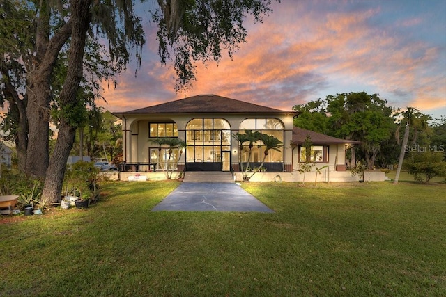 2910 Frontier Dr, Kissimmee, FL 34744 - rear view of house featuring a lawn and stucco siding