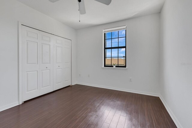 5550 E Michigan St Unit 3325, Orlando, FL 32822 - unfurnished bedroom featuring baseboards, a closet, and dark wood-type flooring