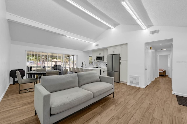 4066 Vanet Ct, Orlando, FL 32822 - living area featuring lofted ceiling with beams, visible vents, and light wood-style floors