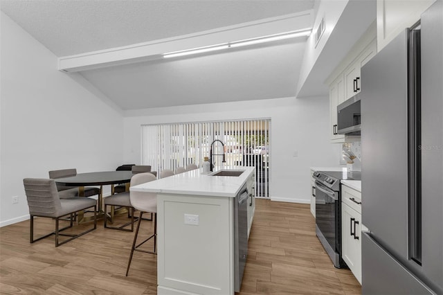4066 Vanet Ct, Orlando, FL 32822 - kitchen featuring a sink, lofted ceiling with beams, a kitchen breakfast bar, appliances with stainless steel finishes, and a center island with sink