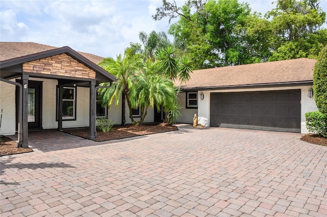 view of front of property featuring a garage, decorative driveway, and stucco siding