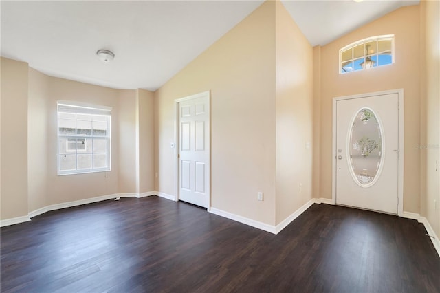 foyer featuring dark wood finished floors, baseboards, and vaulted ceiling