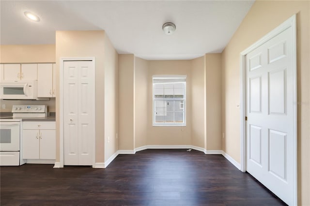 kitchen with white cabinetry, dark wood-style floors, and white appliances