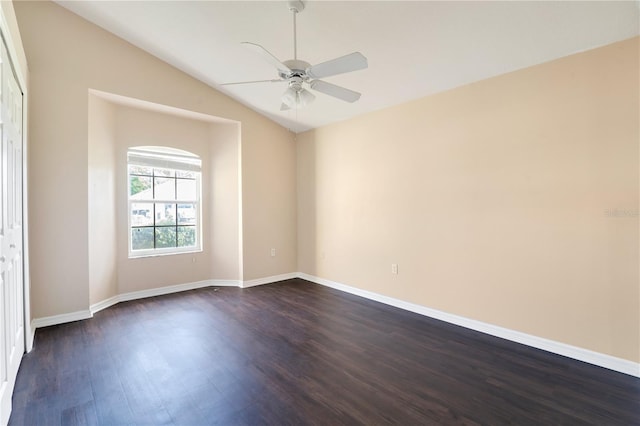 empty room with baseboards, lofted ceiling, ceiling fan, and dark wood-type flooring