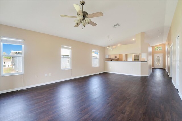 unfurnished living room featuring vaulted ceiling, ceiling fan with notable chandelier, baseboards, dark wood finished floors, and visible vents