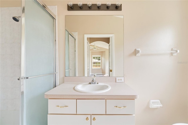 bathroom featuring vanity, ceiling fan, and a shower stall