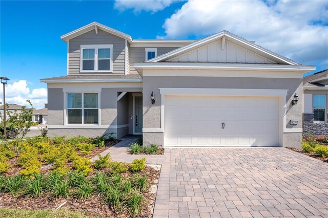 13231 Panama Beach Ct, Orlando, FL 32827 - view of front facade featuring stucco siding, decorative driveway, a garage, and board and batten siding