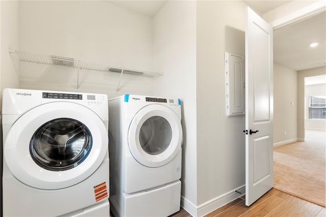 13231 Panama Beach Ct, Orlando, FL 32827 - laundry area featuring electric panel, wood finished floors, baseboards, washer and dryer, and recessed lighting