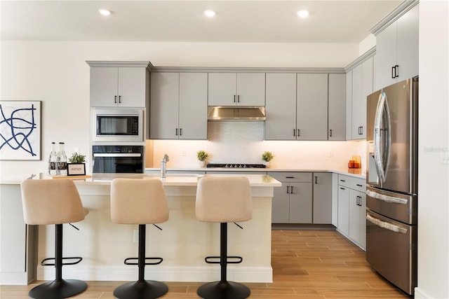 13231 Panama Beach Ct, Orlando, FL 32827 - kitchen featuring black appliances, gray cabinetry, under cabinet range hood, light wood-style flooring, and light countertops