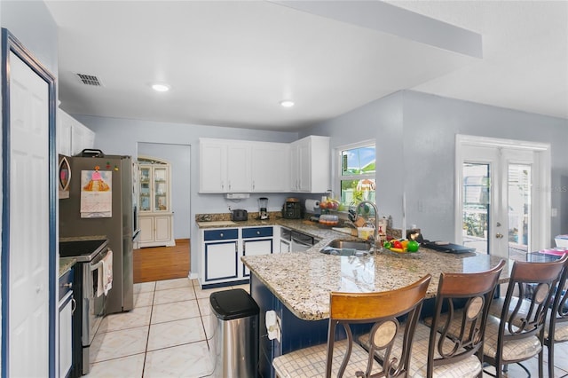103 Nassau Pl, Kissimmee, FL 34758 - kitchen featuring a peninsula, a breakfast bar, appliances with stainless steel finishes, white cabinetry, and a sink