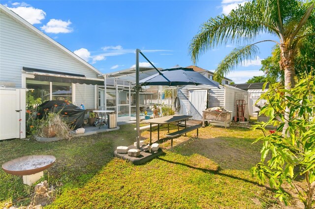 103 Nassau Pl, Kissimmee, FL 34758 - view of yard featuring an outdoor structure, a shed, a pool, glass enclosure, and a patio area