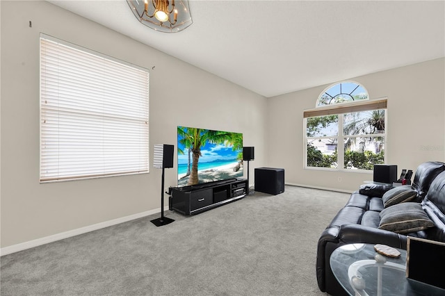 carpeted living room with an inviting chandelier, baseboards, and lofted ceiling