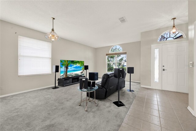tiled living area featuring a textured ceiling, baseboards, and visible vents