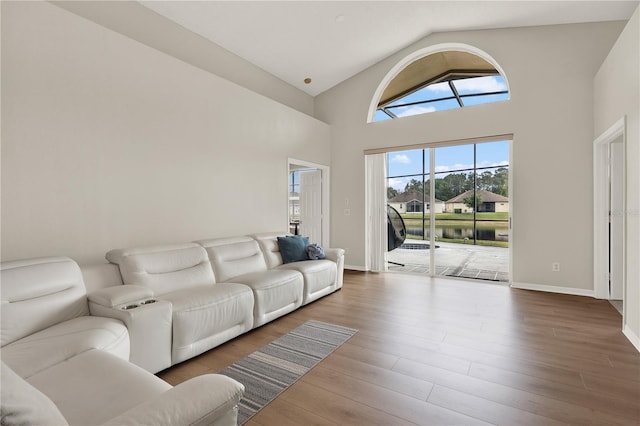 living area featuring baseboards, high vaulted ceiling, and wood finished floors