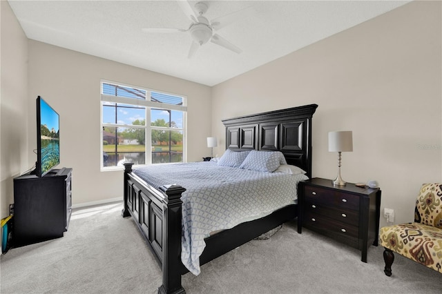 bedroom featuring light colored carpet, ceiling fan, and baseboards