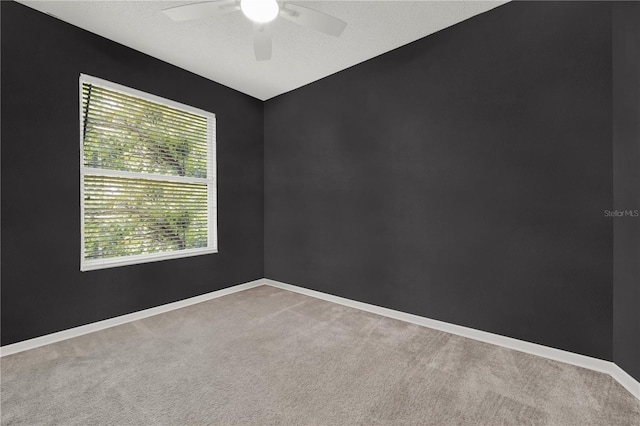 spare room with carpet, baseboards, a textured ceiling, and ceiling fan