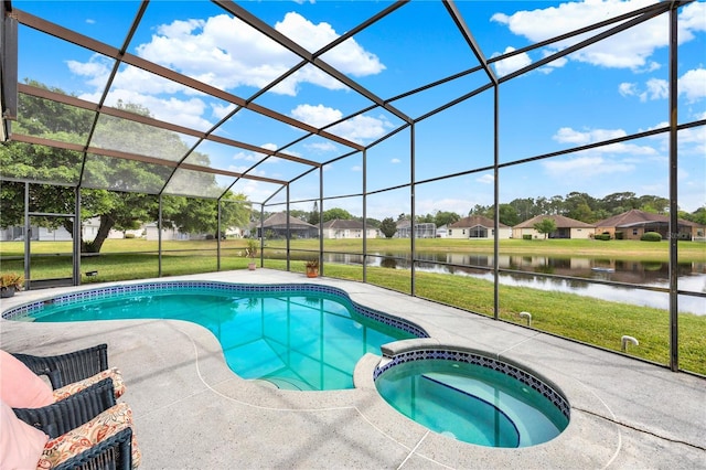view of swimming pool with glass enclosure, a pool with connected hot tub, a patio, a lawn, and a water view