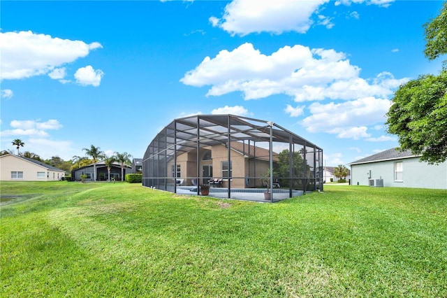 rear view of house featuring a lawn and glass enclosure