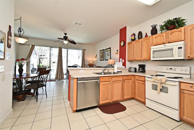 kitchen featuring light countertops, a sink, a peninsula, white appliances, and visible vents