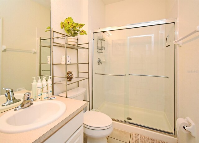 full bathroom with a stall shower, toilet, tile patterned flooring, and vanity