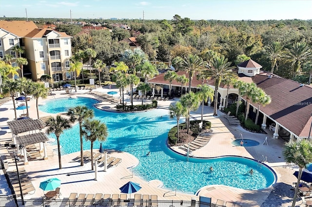 community pool with fence and a patio