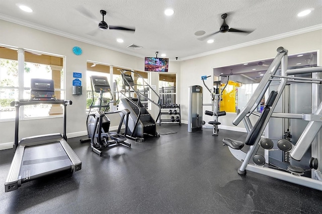 workout area featuring ceiling fan, ornamental molding, and a textured ceiling