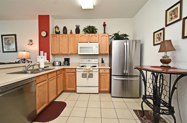 kitchen with light tile patterned floors, light countertops, a sink, and stainless steel appliances