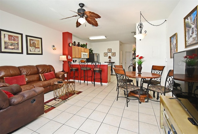 living area with a ceiling fan and light tile patterned floors