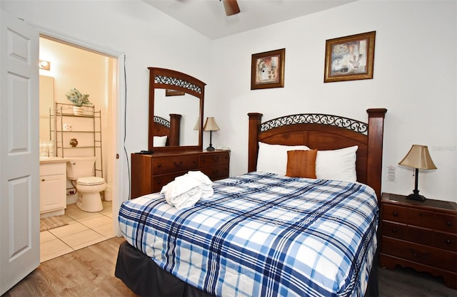 bedroom featuring light wood-style flooring, ensuite bathroom, and a ceiling fan