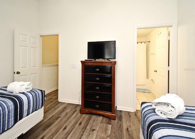 bedroom with ensuite bath and wood finished floors