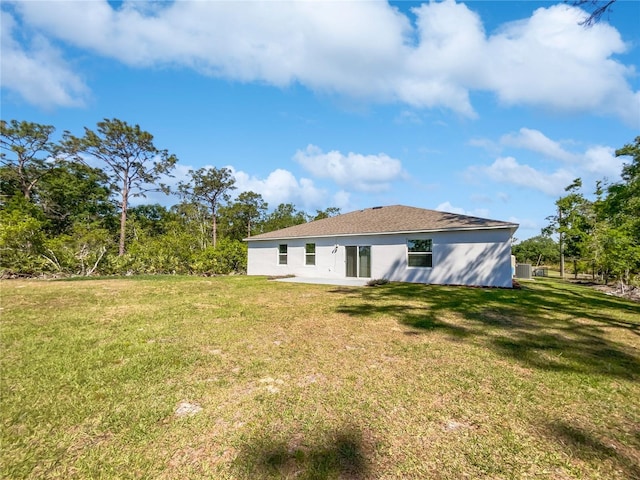 back of property with a lawn and a patio area
