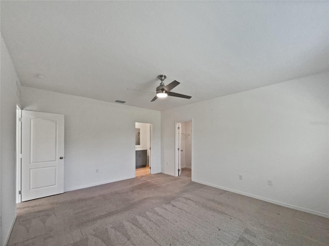 unfurnished bedroom with carpet flooring, a spacious closet, baseboards, connected bathroom, and visible vents