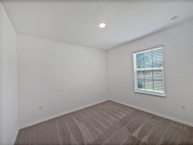empty room featuring baseboards and carpet floors