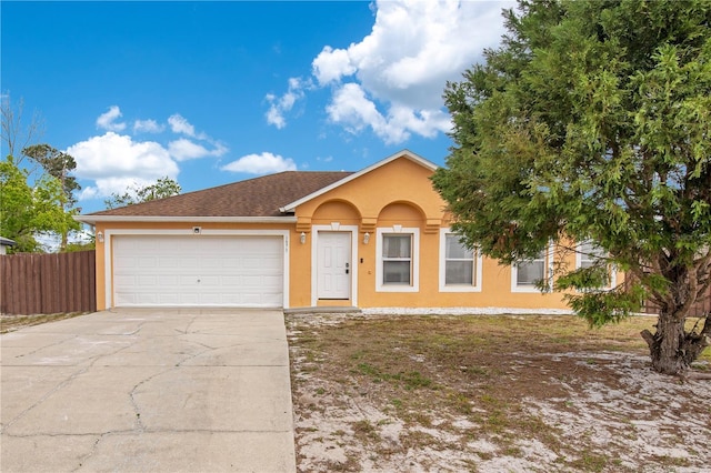 ranch-style house with a garage, concrete driveway, stucco siding, and fence