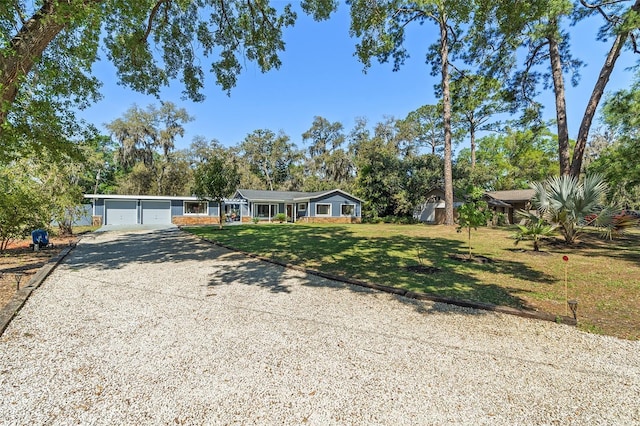 ranch-style house with gravel driveway, a front lawn, and a garage