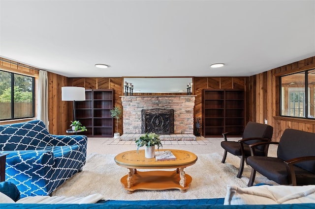 carpeted living room featuring wooden walls and a fireplace
