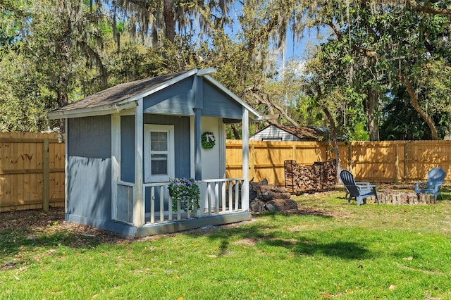 view of shed featuring a fenced backyard and an outdoor fire pit