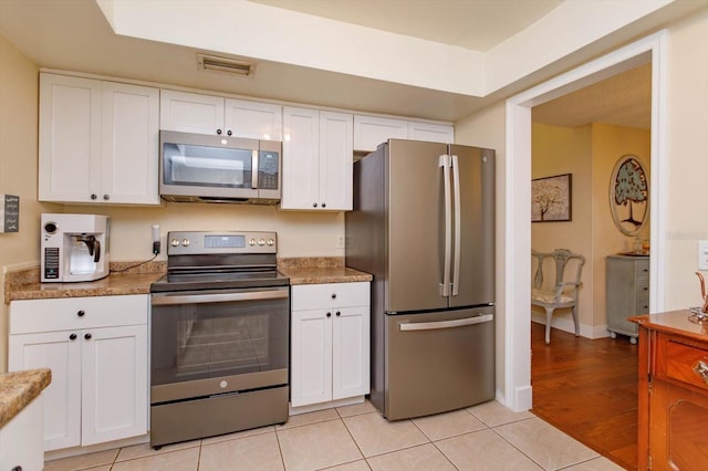 487 Oak Haven Dr Unit 487, Altamonte Springs, FL 32701 - kitchen with visible vents, white cabinetry, light tile patterned floors, and stainless steel appliances