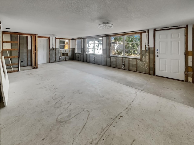 2826 46th St S, Gulfport, FL 33711 - unfurnished living room with concrete floors and a textured ceiling